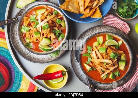 Mexican style table with spicy aztec soup with tortilla. Copy space. Stock Photo