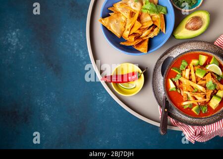 Mexican style table with spicy aztec soup with tortilla. Copy space. Stock Photo