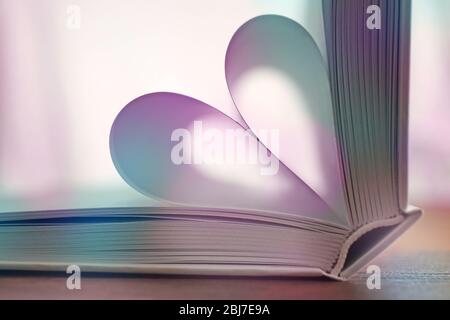 Heart from book pages on blurred background Stock Photo