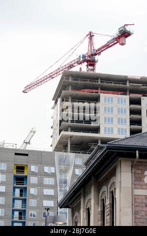 Large crane works on top of a new apartment building and high rise garage in a big USA city Stock Photo