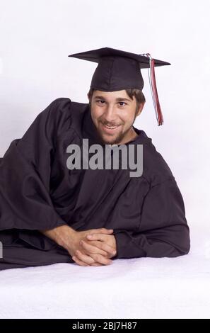 Proud high school senior poses in cap and gown for a graduation photo Stock Photo