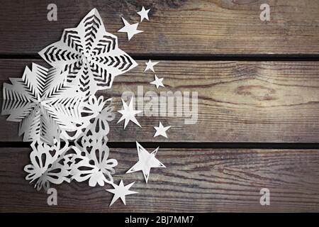 Winter background with hand-made paper snowflakes on wooden background Stock Photo