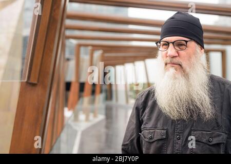 Mature bearded man thinking at footbridge in the city Stock Photo - Alamy