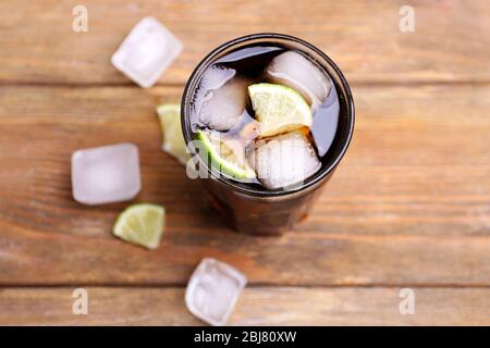Cocktail with lime slices and ice blocks on wooden table, top view Stock Photo