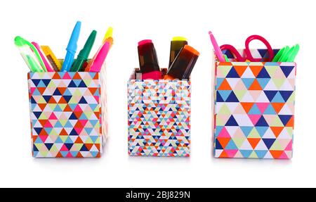 Three bright holders full of office supplies isolated on white background Stock Photo