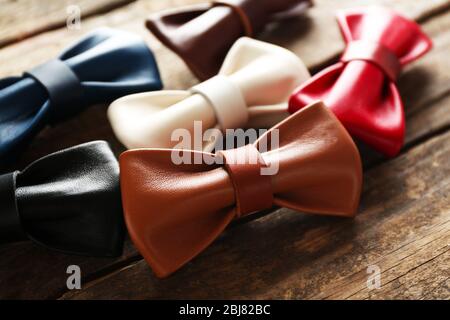 A set of colorful leather bow ties on a brown wooden background Stock Photo