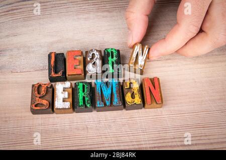 LEARN GERMAN. Language training, skills and education concept. Colored wooden letters on a light background Stock Photo