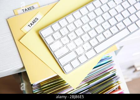 Folders with tax documents and keyboard, close up Stock Photo