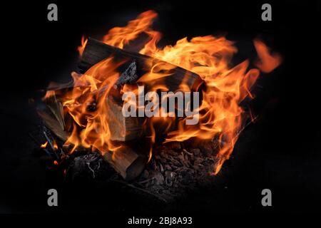 Fire flames with sparks on  coals on black background Stock Photo