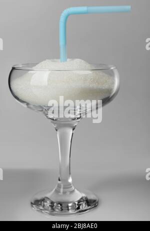 Margarita glass with granulated sugar and cocktail straw on grey background Stock Photo