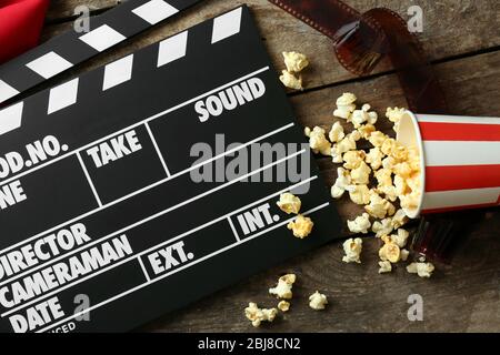 Movie clapper board with popcorn on the wooden table. Stock Photo