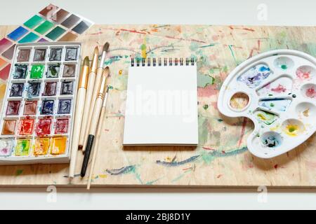 Premium Photo  Brushes watercolor palette and empty sketchbook