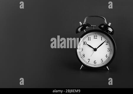 A retro alarm-clock on dark grey background. Stock Photo