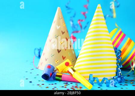 Birthday hats with serpentine streamer and noise makers on blue background Stock Photo