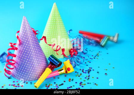 Two Birthday hats with serpentine streamer and noise makers on blue background Stock Photo