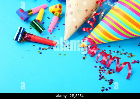 Birthday hats with serpentine streamer and noise makers on blue background Stock Photo