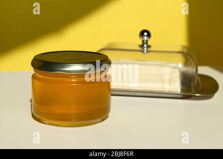 Ghee or clarified butter in jar. Healthy eating and using organic fresh made products. Healthy ingredient for cooking organic meal. Front view. Stock Photo