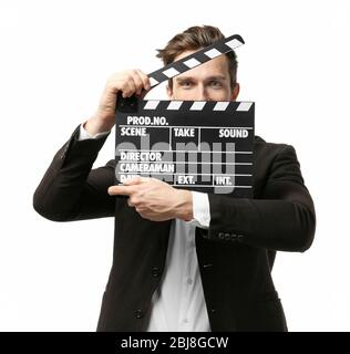 Young man in a suit holding a movie clapperboard, on white background Stock Photo