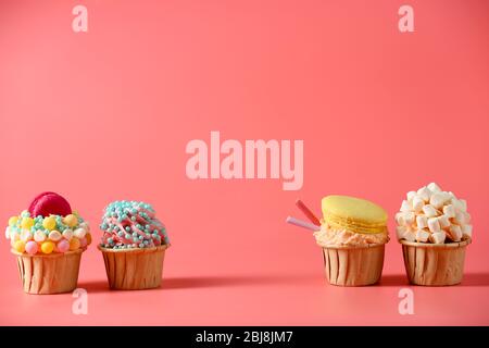 Tasty cupcakes with original decoration on pink background Stock Photo