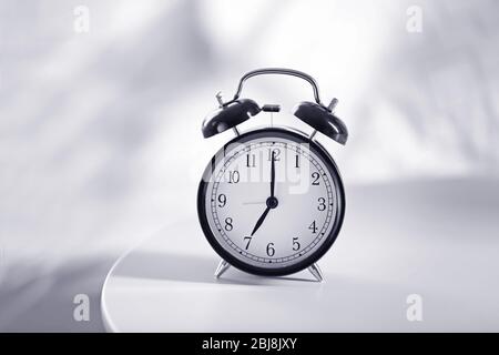 Vintage alarm clock on bedside table in a room Stock Photo