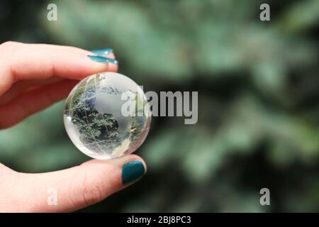 Female hand holding small glass globe closeup Stock Photo