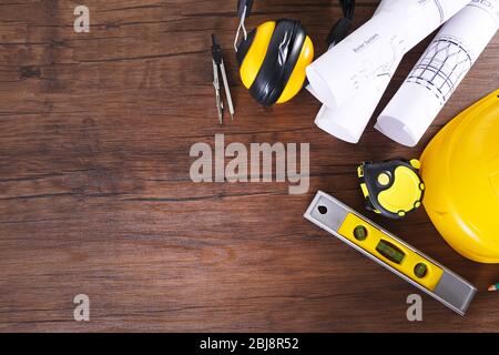Construction blueprints with tools and helmet on wooden table, top view Stock Photo