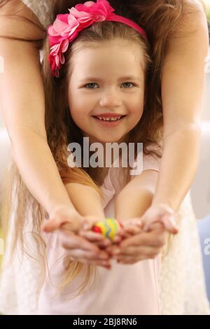 Mother and daughter holding decorated Easter egg closeup Stock Photo