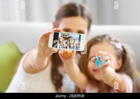 Mother and daughter making selfie, indoors Stock Photo