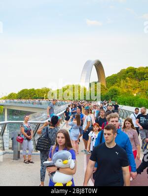 KIEV, UKRAINE - MAY 31, 2019:  Crowd of people at new Pedestrian-Bicycle Bridge at sunset. New Klitschko Pedestrian-Bicycle Bridge one of the most int Stock Photo