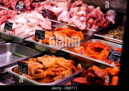 Variety of raw and pickled meat displayed in shop counter with price and name tag. The meat department of the supermarket. Inscriptions in Russian mea Stock Photo