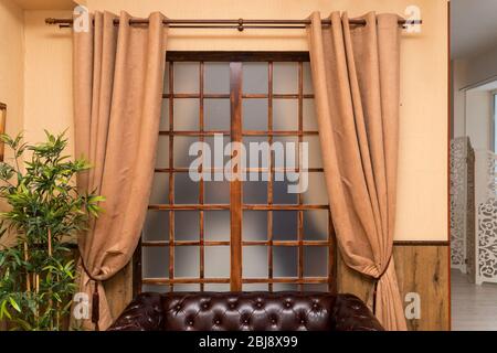 Brown curtains in front of the window in the room Stock Photo