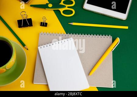 Notebook and pen with a place for writing. Workspace with stationery, top view. Remote remote work online. Study and creativity. Yellow and green Stock Photo