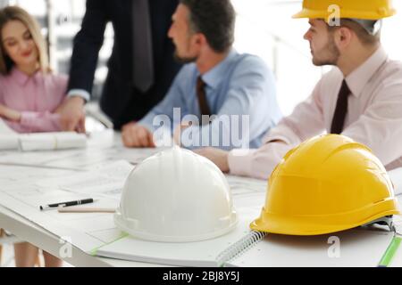 Helmets and blueprints on the office table Stock Photo