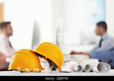 Yellow helmets on office table on blurred background Stock Photo
