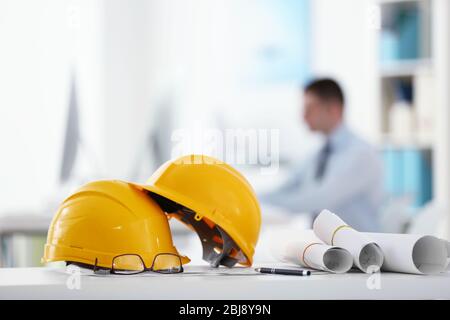 Yellow helmets on office table on blurred background Stock Photo
