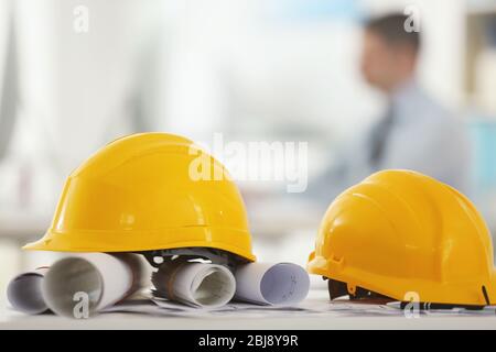 Yellow helmets on office table on blurred background Stock Photo