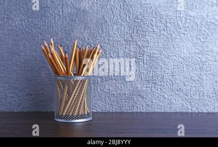 Pencils in metal holder on the table, closeup Stock Photo
