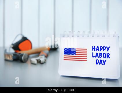 Notebook with printed text HAPPY LABOR DAY on grey table closeup Stock Photo