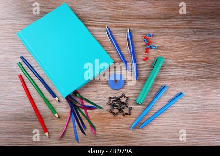 Notebook with stationery on wooden background Stock Photo