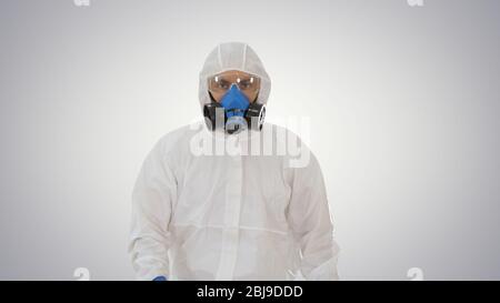 Man wearing hazmat suit walking on gradient background. Stock Photo