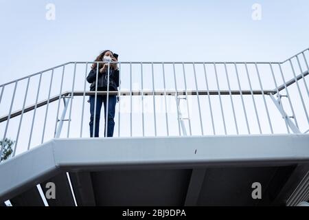 Caucasian woman wearing a protective mask and using her phone Stock Photo