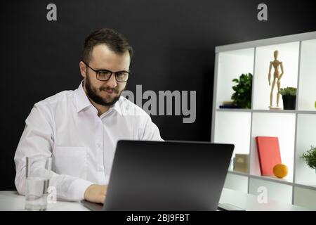 Pleasant businessman surfing the net in cozy office workplace. working at home Stock Photo