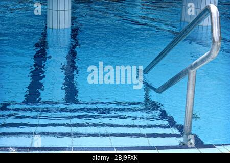 Grab bars ladder in swimming pool Stock Photo