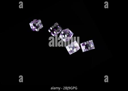 Purple Casino dices over black background Shallow depth of field Stock Photo