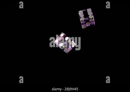 Purple Casino dices over black background Shallow depth of field Stock Photo