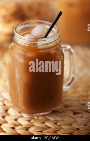Iced coffee in glass jar on wicker table Stock Photo