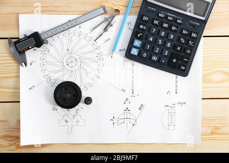 Engineering drawings of parts with tools on wooden table Stock Photo