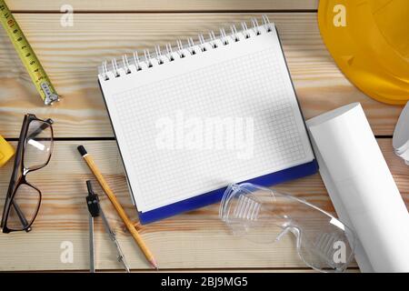 Notebook with construction tools on wooden background Stock Photo