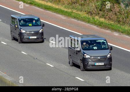 Two Vauxhall Vivaro CDTI S/S vans; UK Vehicular traffic, transport, modern commercial vans, panel van, business vehicle, south-bound on the 3 lane M6 motorway highway. Stock Photo