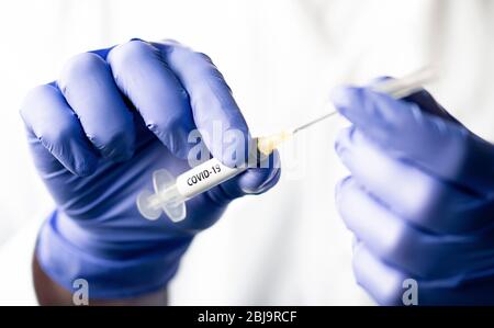 Coronavirus vaccine concept. Nurse holding needle ready for covid 19 cure and immunity. Doctor preparing syringe. Corona virus shot in hospital. Stock Photo